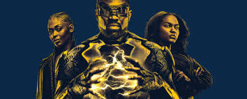 Image Description: a medium-sized banner picture. The background is navy blue. In the foreground is a trio of people (posing Charlie's Angels style) with a yellow-sepia tinted colour over the image. The three people from left to right:  Anissa Pierce/Thunder, Jefferson Pierce/Black Lightning, and Jennifer Pierce.